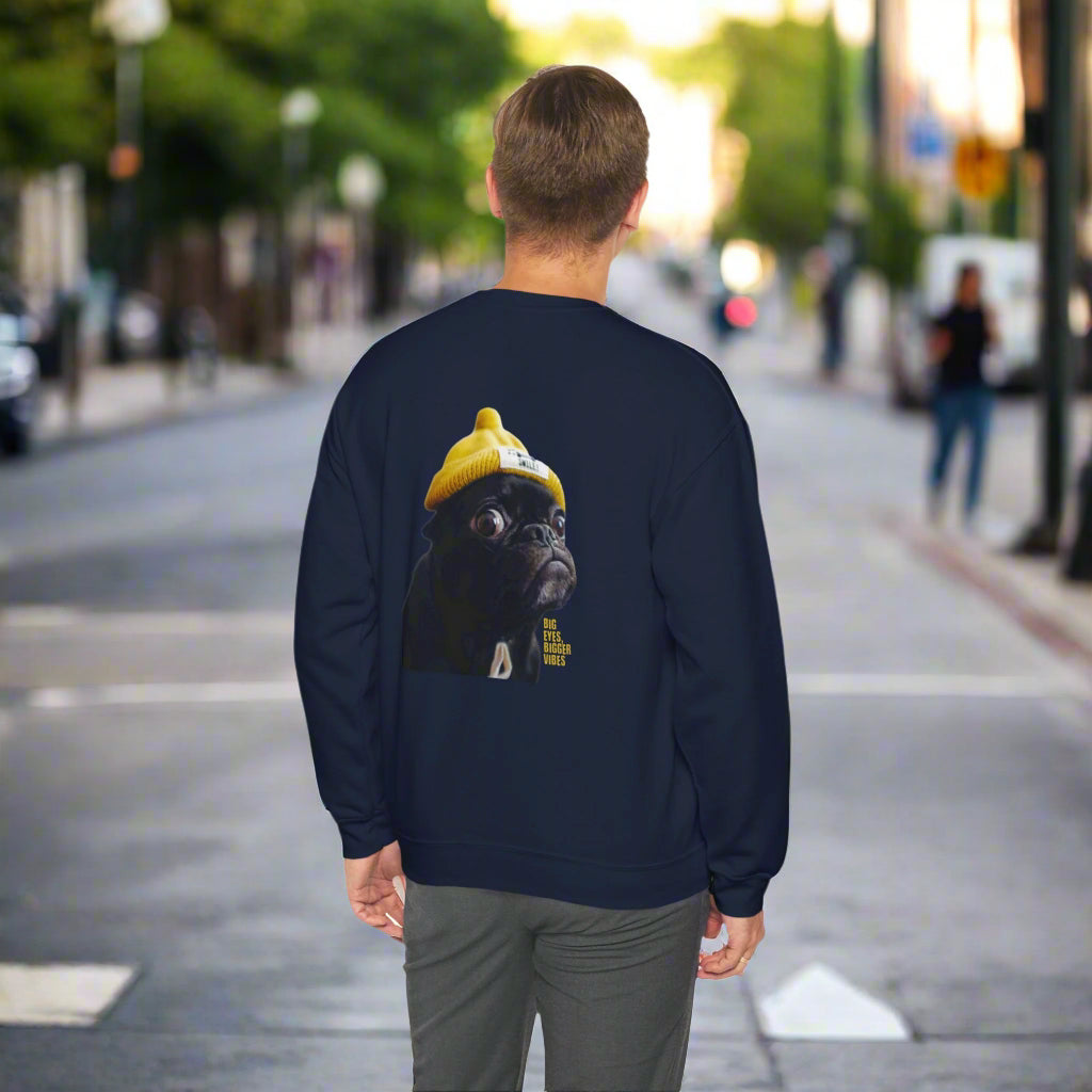Person wearing a navy blue sweatshirt with a graphic of a pug on the back, walking down a city street.
